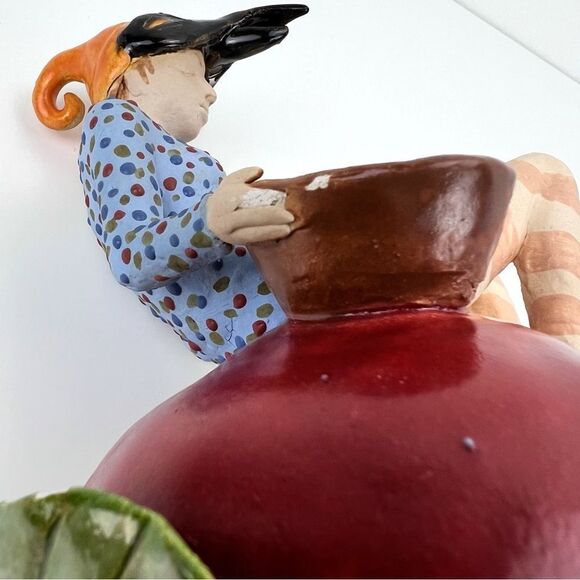 CARRIANNE L HENDRICKSON woman with beak hat sitting on apple sculpture 2… - Picture 14 of 16